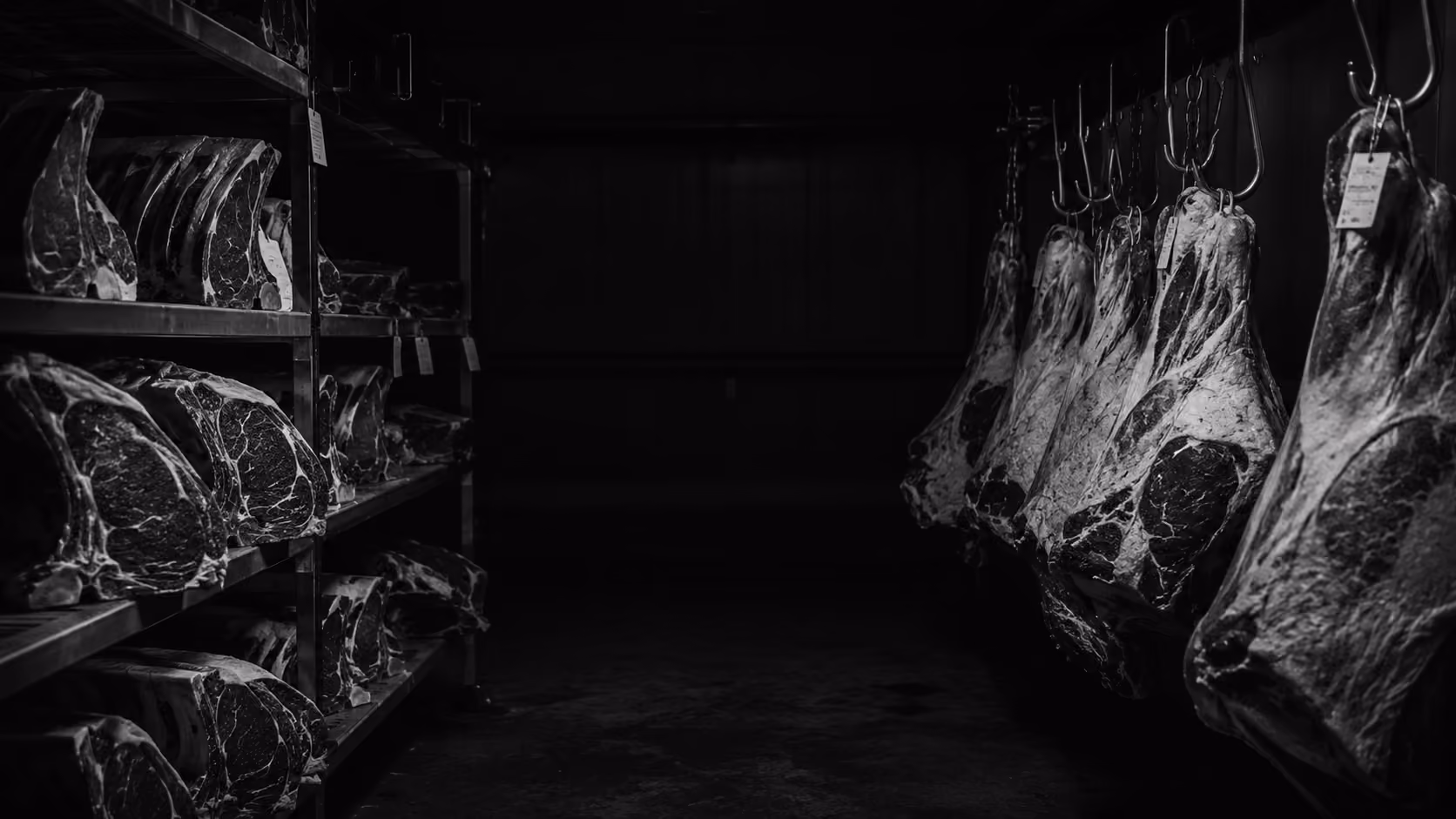 Cuts of beef aging on racks in Norden's dry-aging room