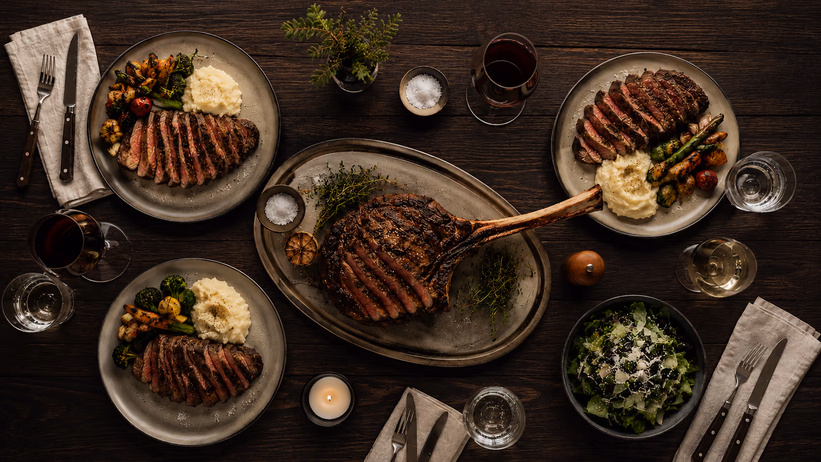 Dark oak table set with Scandinavian steaks, shot from above